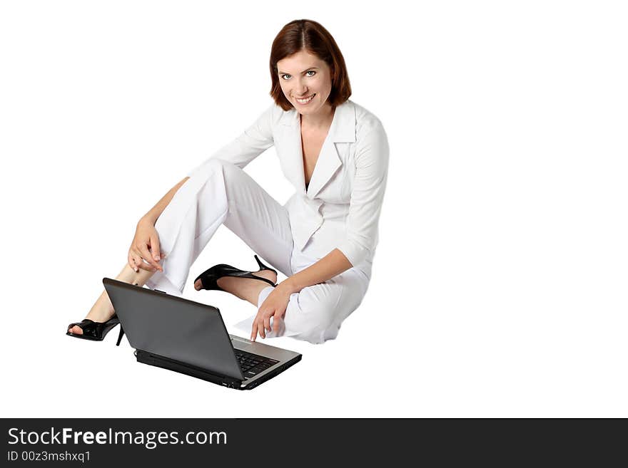 Businesswoman in white clothes sits near a laptop on a floor