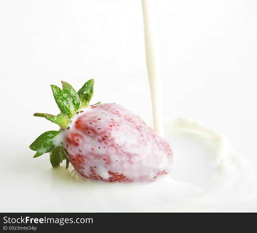 An image of red strawberry in milk. An image of red strawberry in milk