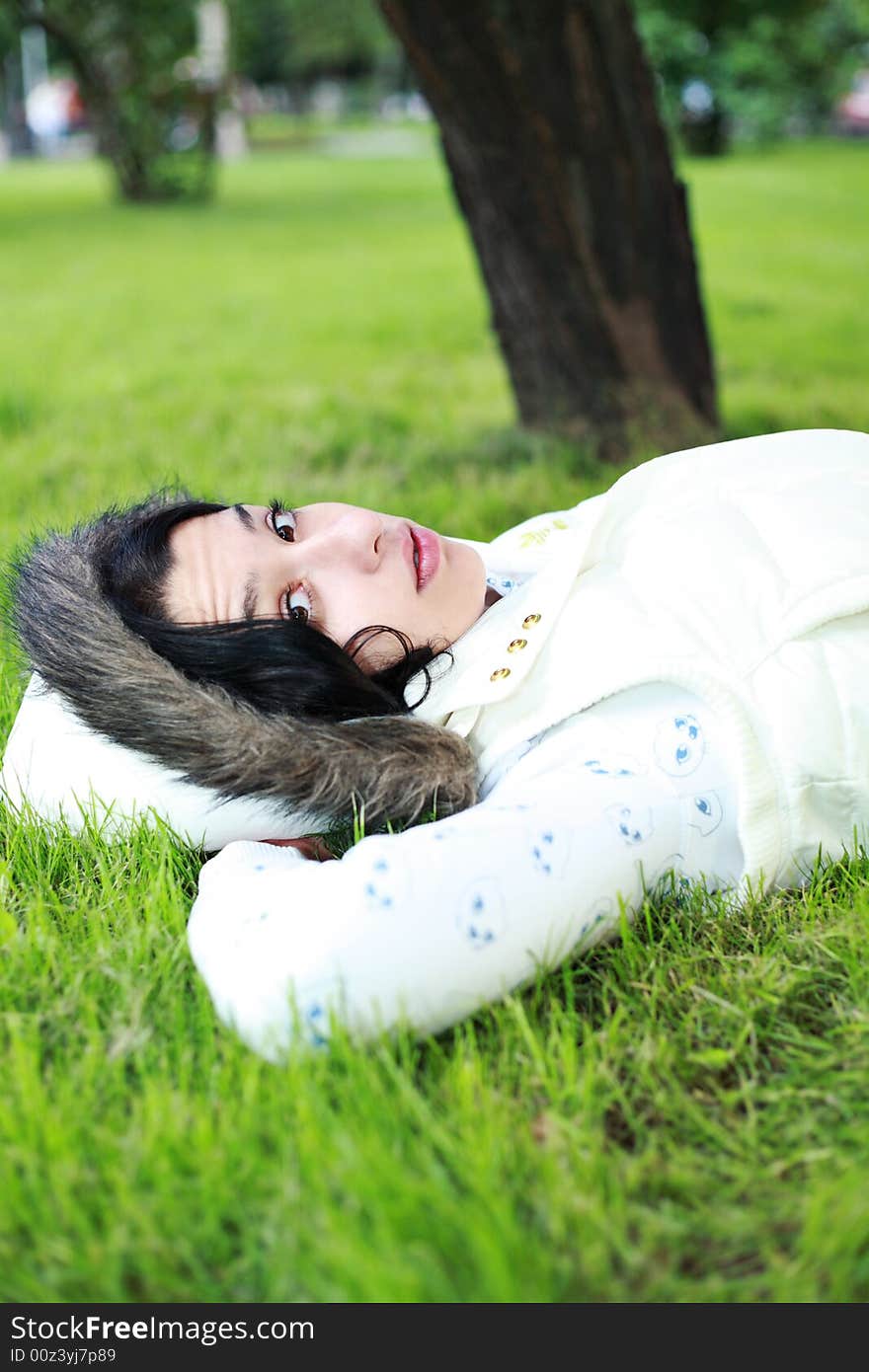 Beautiful girl lying down of grass