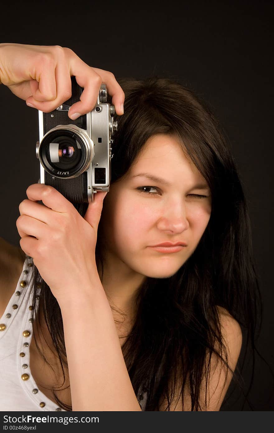 Attractive girl with retro camera isolated in studio