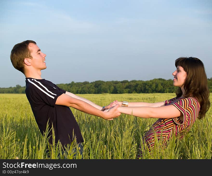 Teen Couple Holding hands Field looking each other