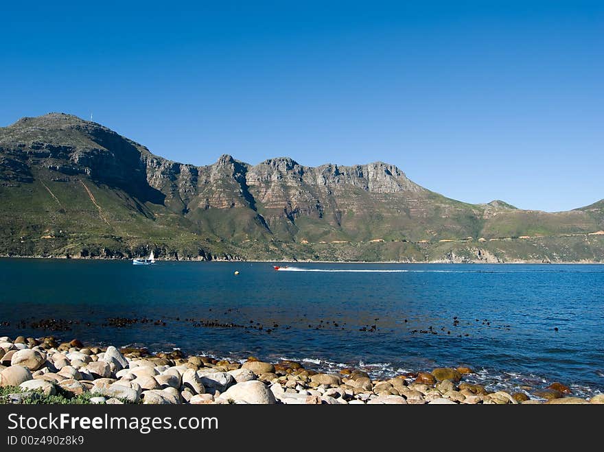 A fast red boat enjoying a clear crisp morning in Hout bay which is found in the city of Cape Town, South Africa. A fast red boat enjoying a clear crisp morning in Hout bay which is found in the city of Cape Town, South Africa.