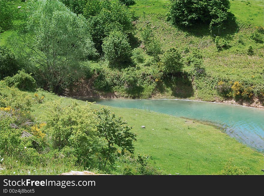 A view of mountain landscape with a small lake. A view of mountain landscape with a small lake