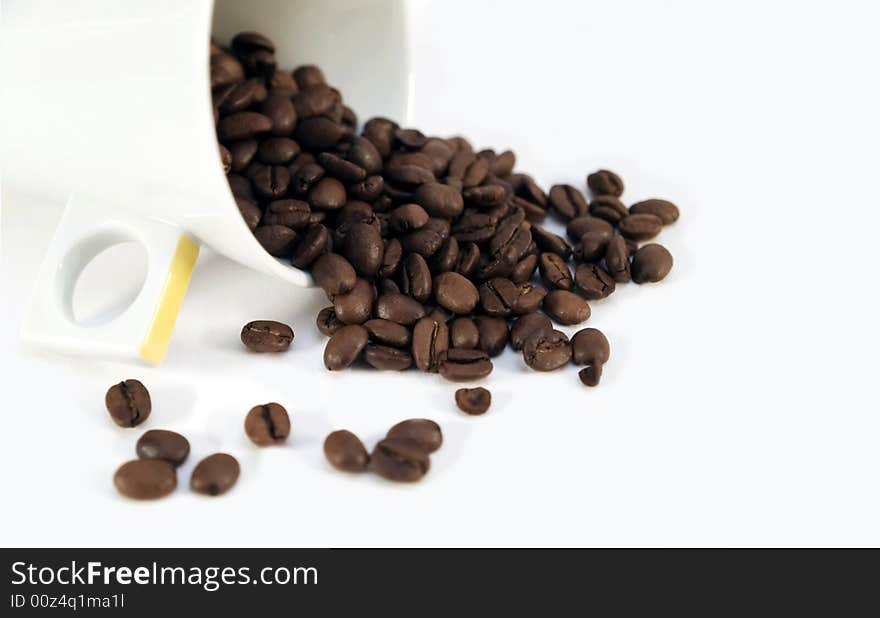 Coffee beans and a white cup on white background