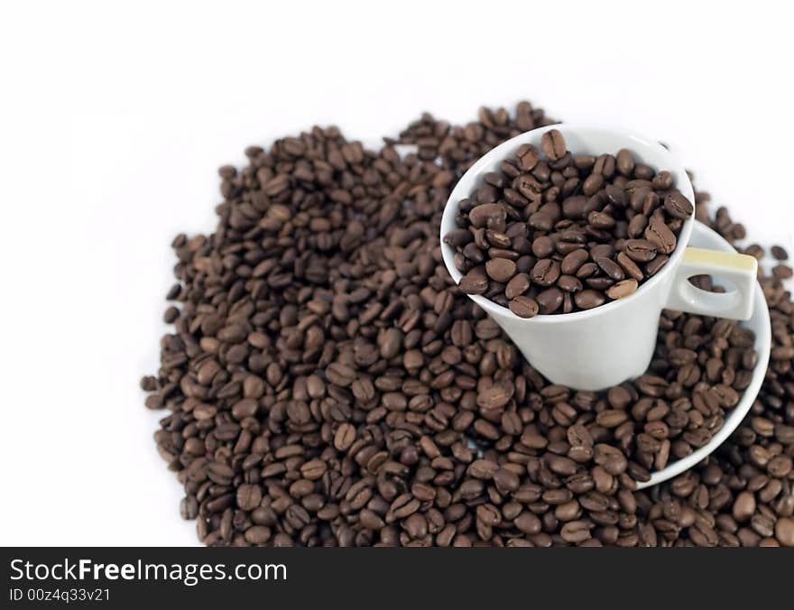 Coffee beans and a white cup on white background