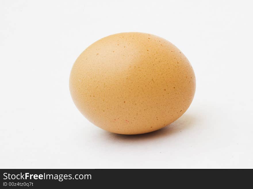 Speckled egg laying down against white background