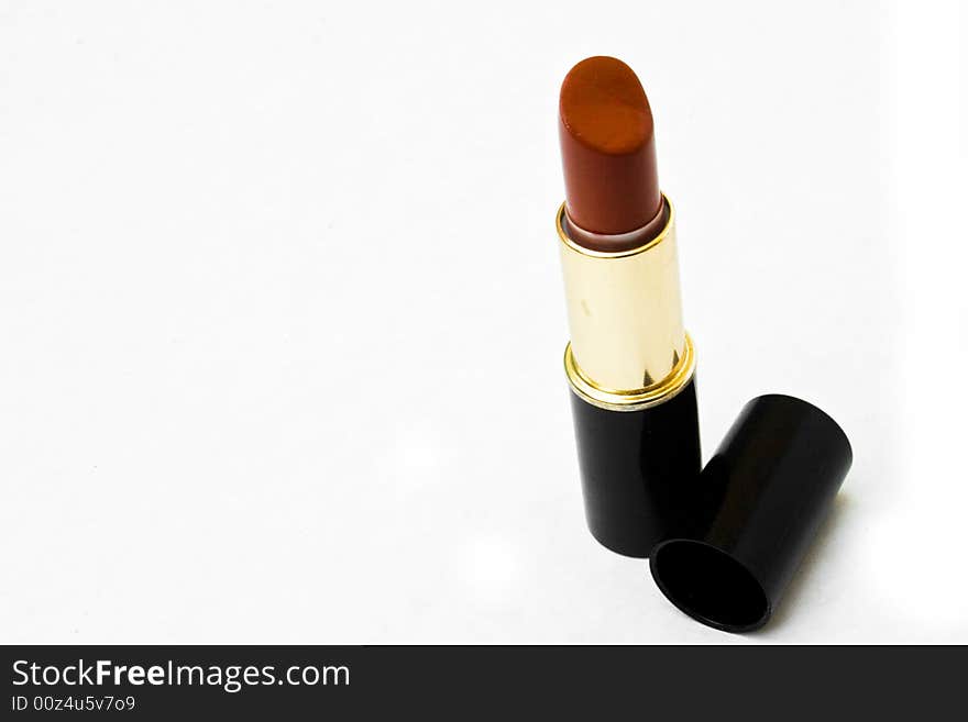 Lipstick standing on end with cap next to it. Lipstick standing on end with cap next to it