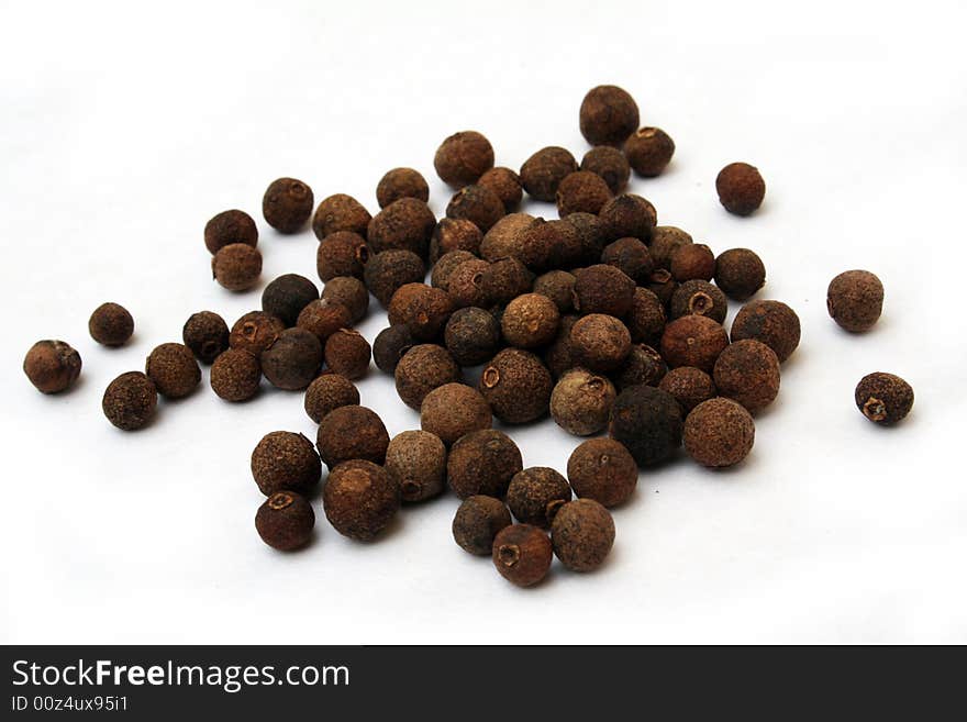 Allspice whole fruits on white background on diagonal