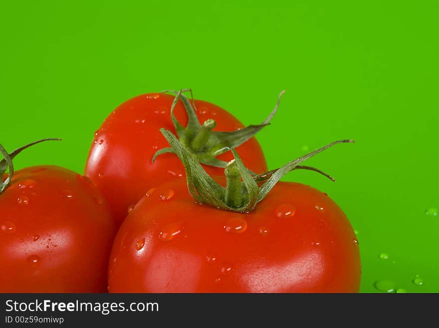 Three tomatoes on green