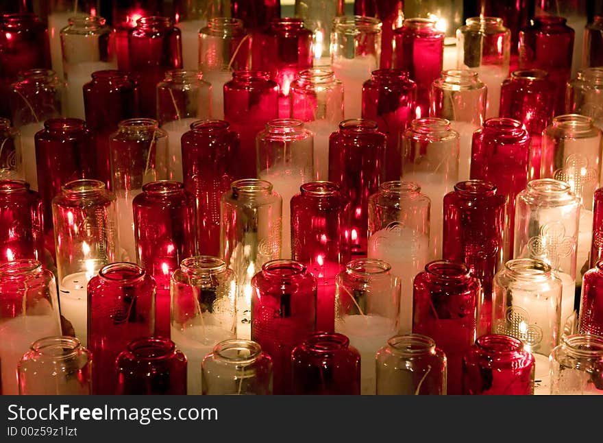 Candles in color glasses in a church. Candles in color glasses in a church