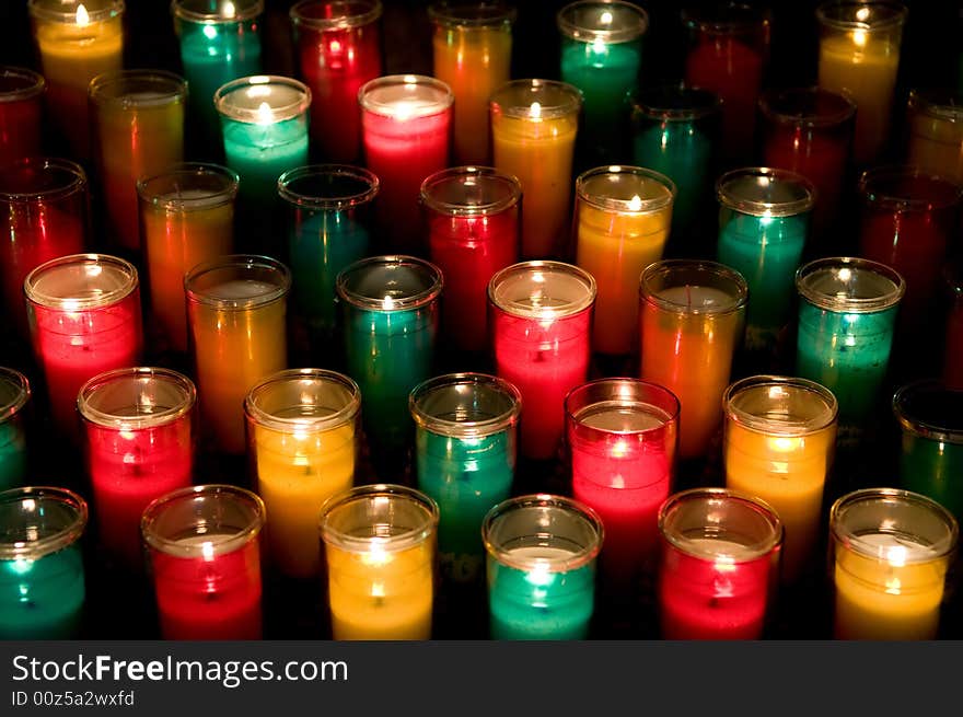 Candles in color glasses in a church. Candles in color glasses in a church