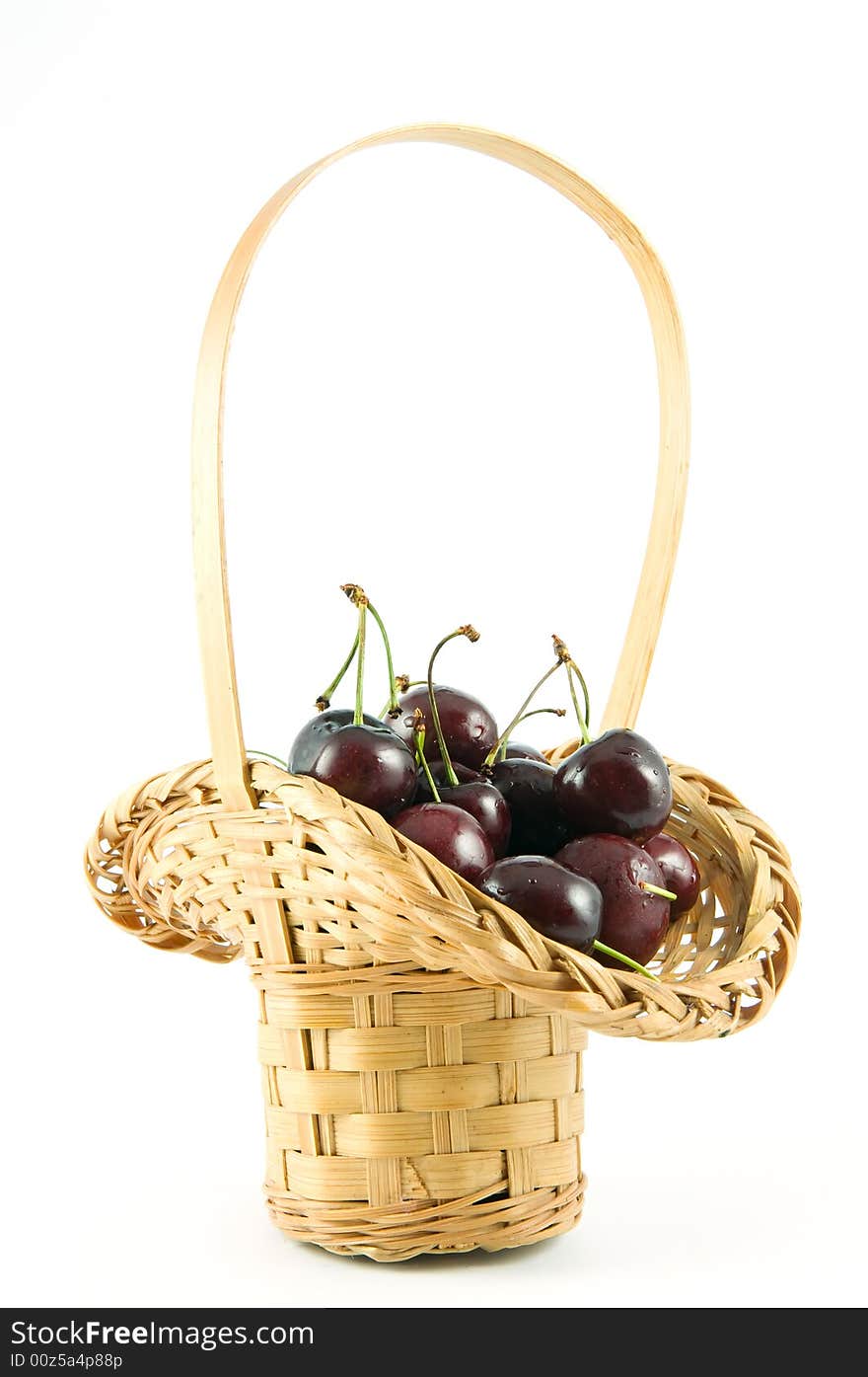 Small straw basket of cherries isolated on white background