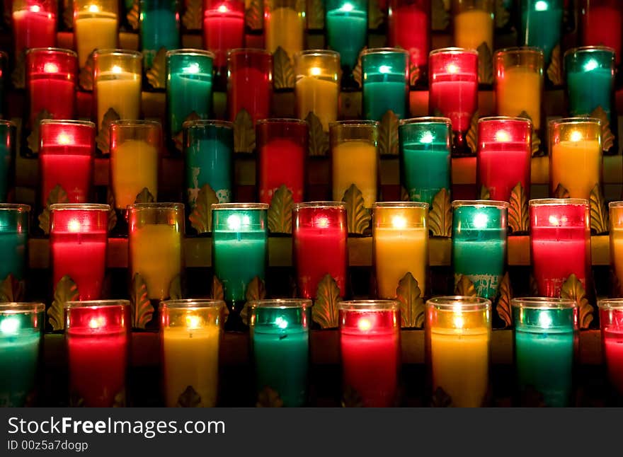 Candles in color glasses in a church. Candles in color glasses in a church