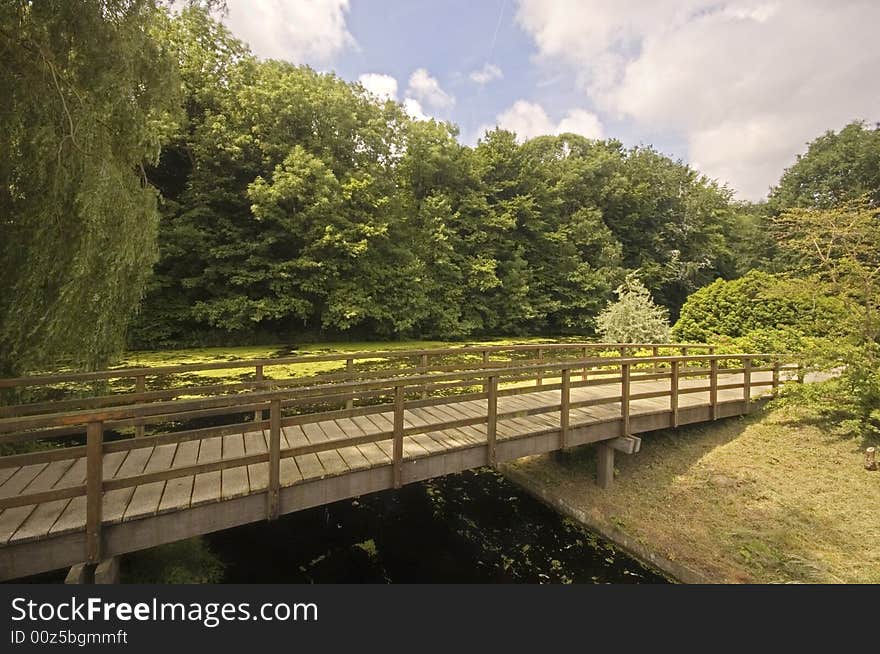 Wooden bridge in a park next to a dutch canal