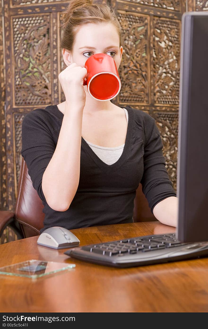 Female executive working on a PC keyboard and/or mouse on a wooden desk. Female executive working on a PC keyboard and/or mouse on a wooden desk.