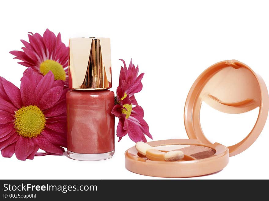 Fashionable dark pink nail polish with daisy flowers and golden eyeshadow set isolated on white background. Fashionable dark pink nail polish with daisy flowers and golden eyeshadow set isolated on white background