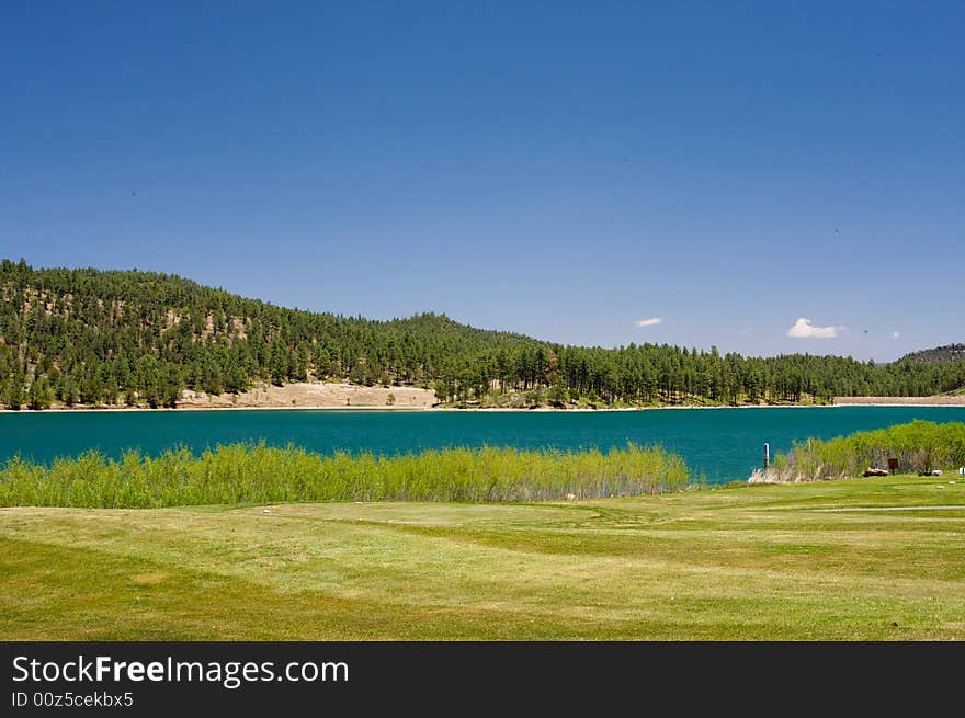 An image of an aqua lake near a golf hole