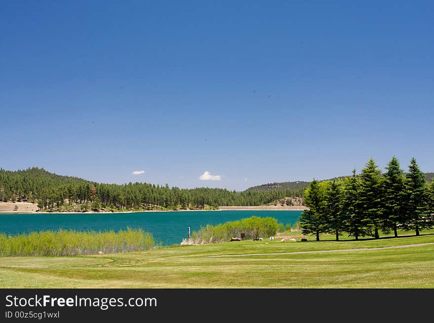 An image of a aqua lake near a golf hole