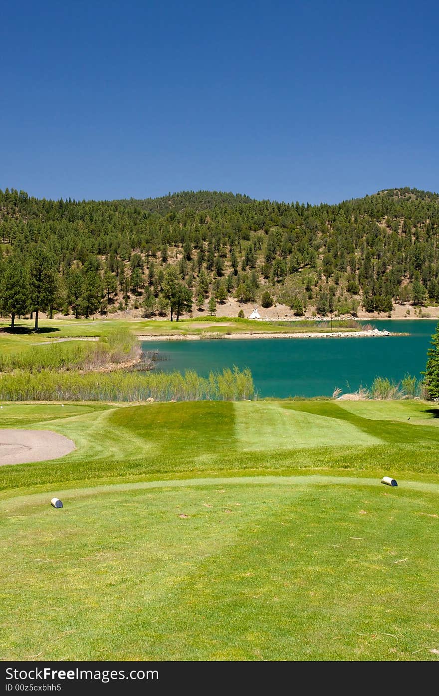 An aqua lake set near a golf hole