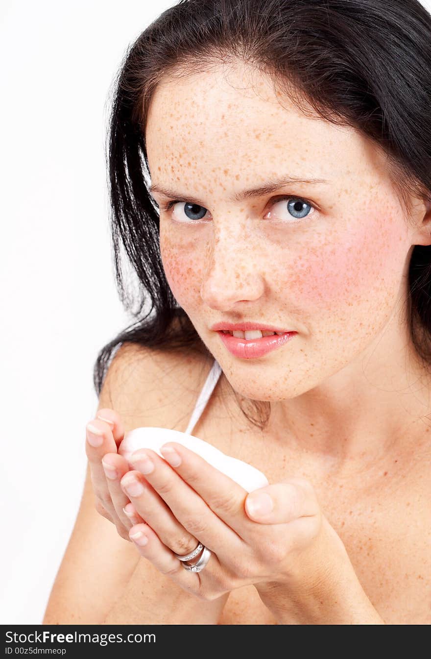 Portrait of a beautiful brunette woman with light blue eyes and freckles on her skin, holding bar of soap. Portrait of a beautiful brunette woman with light blue eyes and freckles on her skin, holding bar of soap