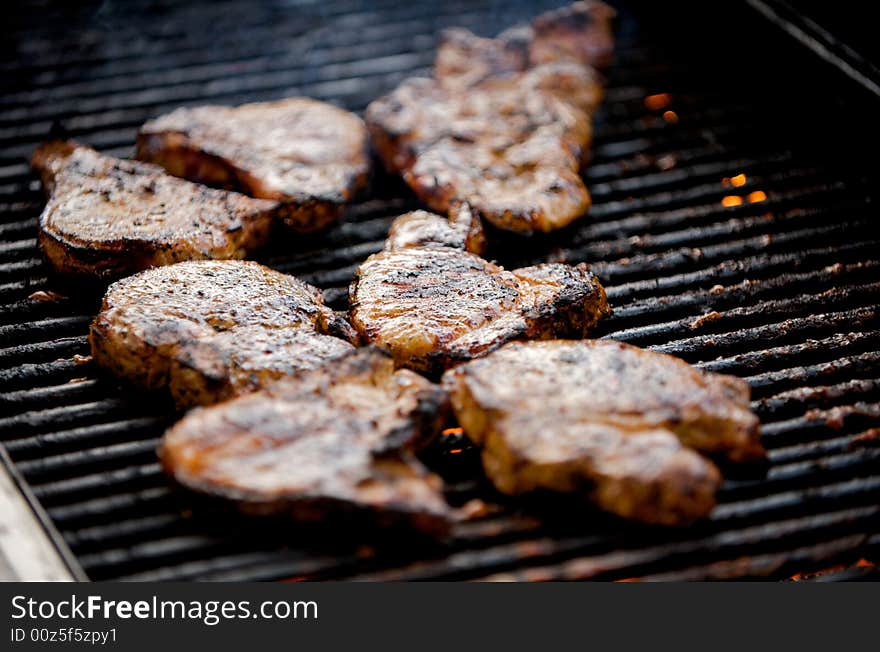 An image of juicy pork chops on a grill