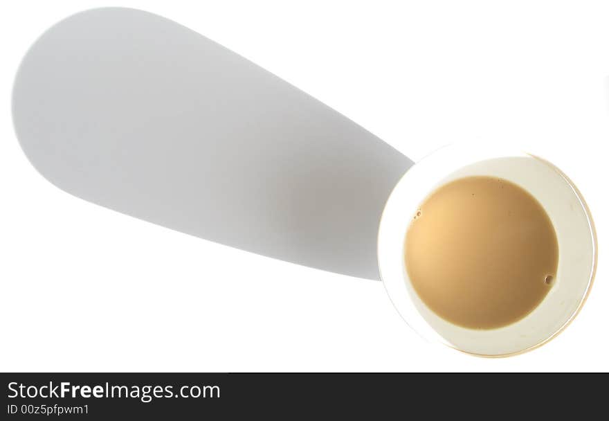 Tea with milk in the cup and shadow,cup of tea on a white background in contrasting light