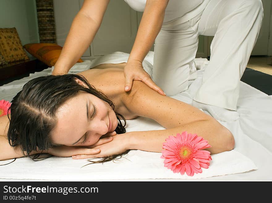 Woman closes her eyes and relaxes as she gets a massage. Horizontally framed photograph. Woman closes her eyes and relaxes as she gets a massage. Horizontally framed photograph.