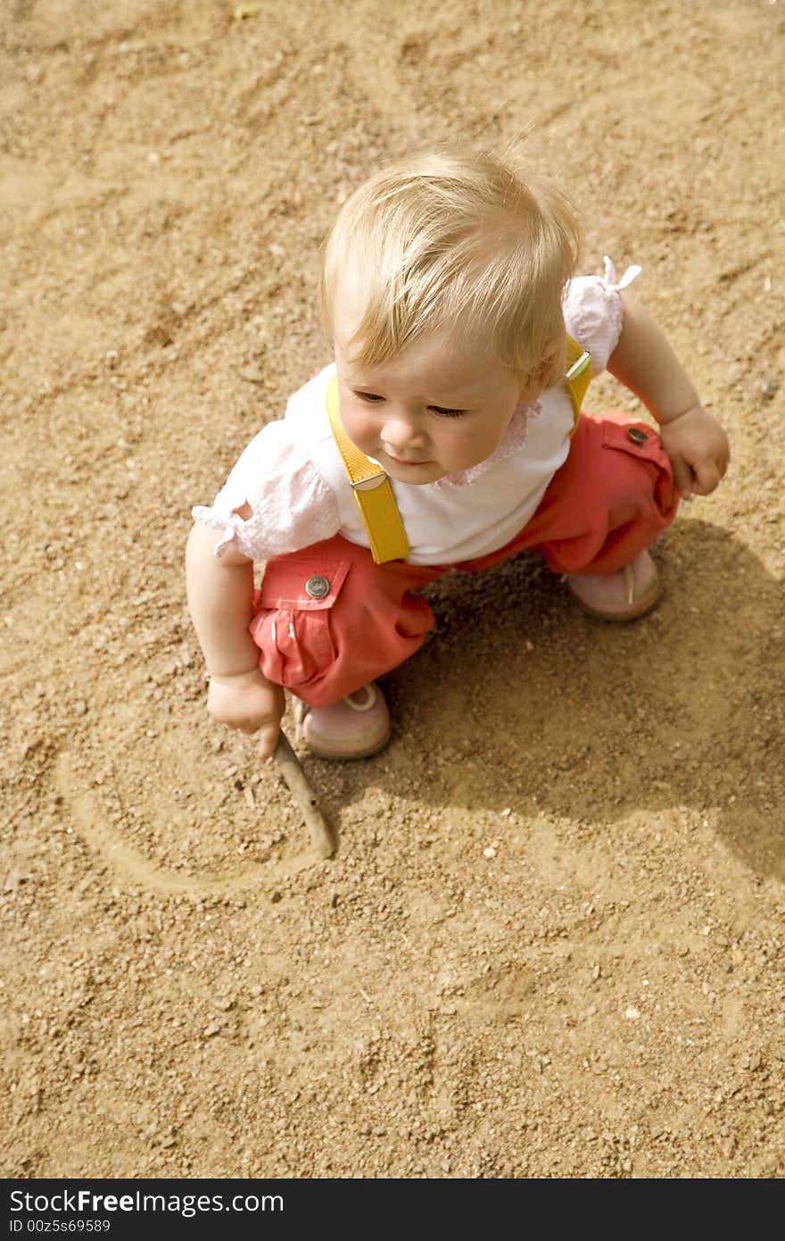 Little girl sitting on a sand on a playground. Little girl sitting on a sand on a playground