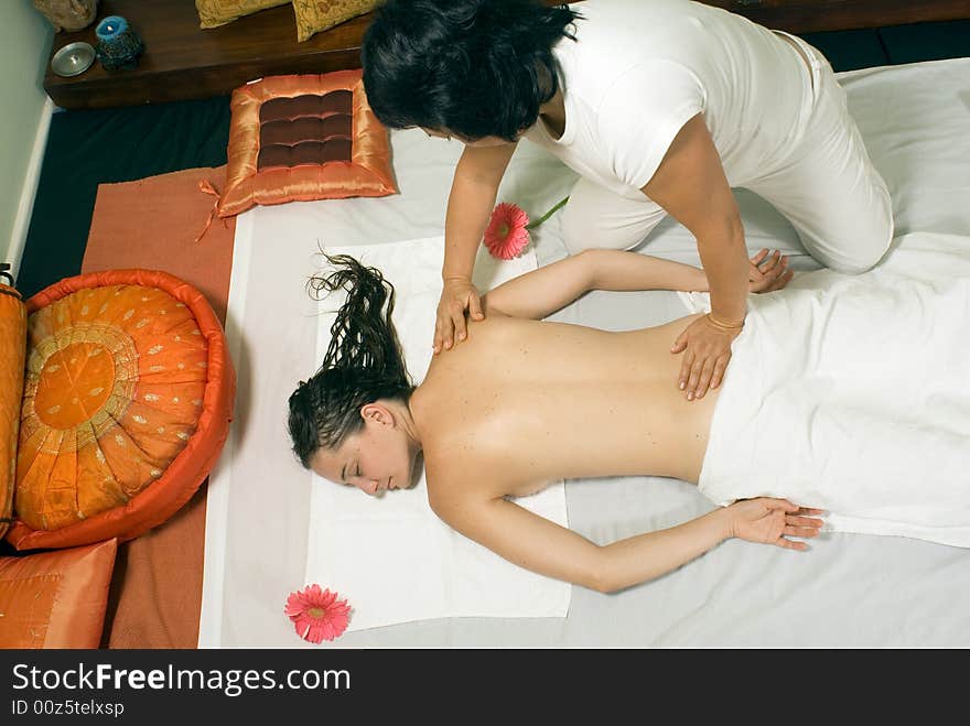 Woman closes her eyes and relaxes as she gets a massage. Horizontally framed photograph. Woman closes her eyes and relaxes as she gets a massage. Horizontally framed photograph.