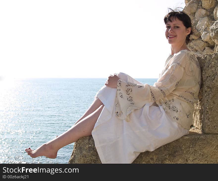 Young Smiling Lady Sitting on Stone Relaxed Looking to Camera. Young Smiling Lady Sitting on Stone Relaxed Looking to Camera