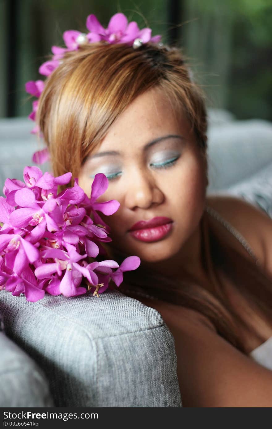 Asian bride with beautiful pink flowers in her hair.