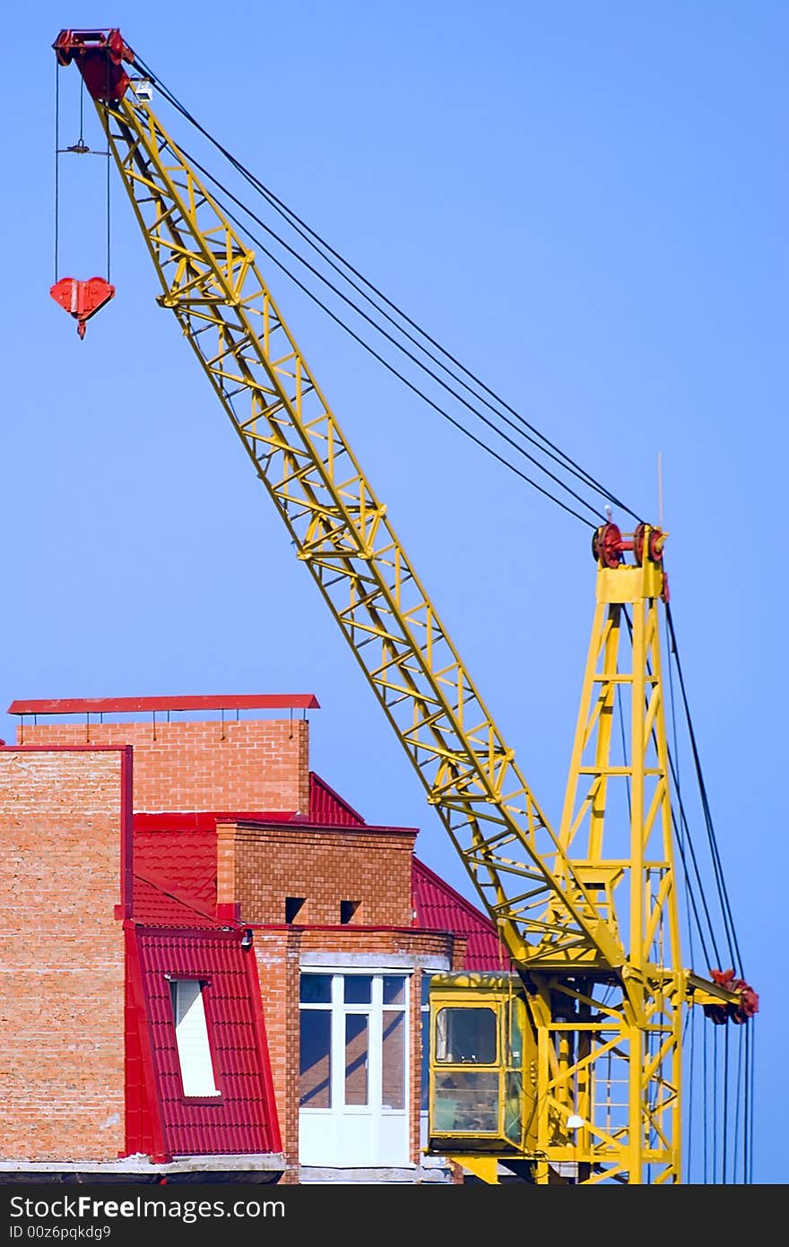 The building crane stands near a abuilding house. The building crane stands near a abuilding house