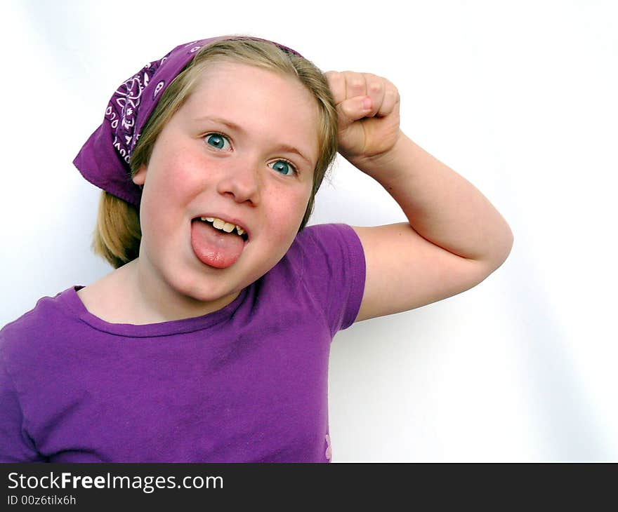 A little girl dressed all in purple is pounding her head and making a funny face. A little girl dressed all in purple is pounding her head and making a funny face