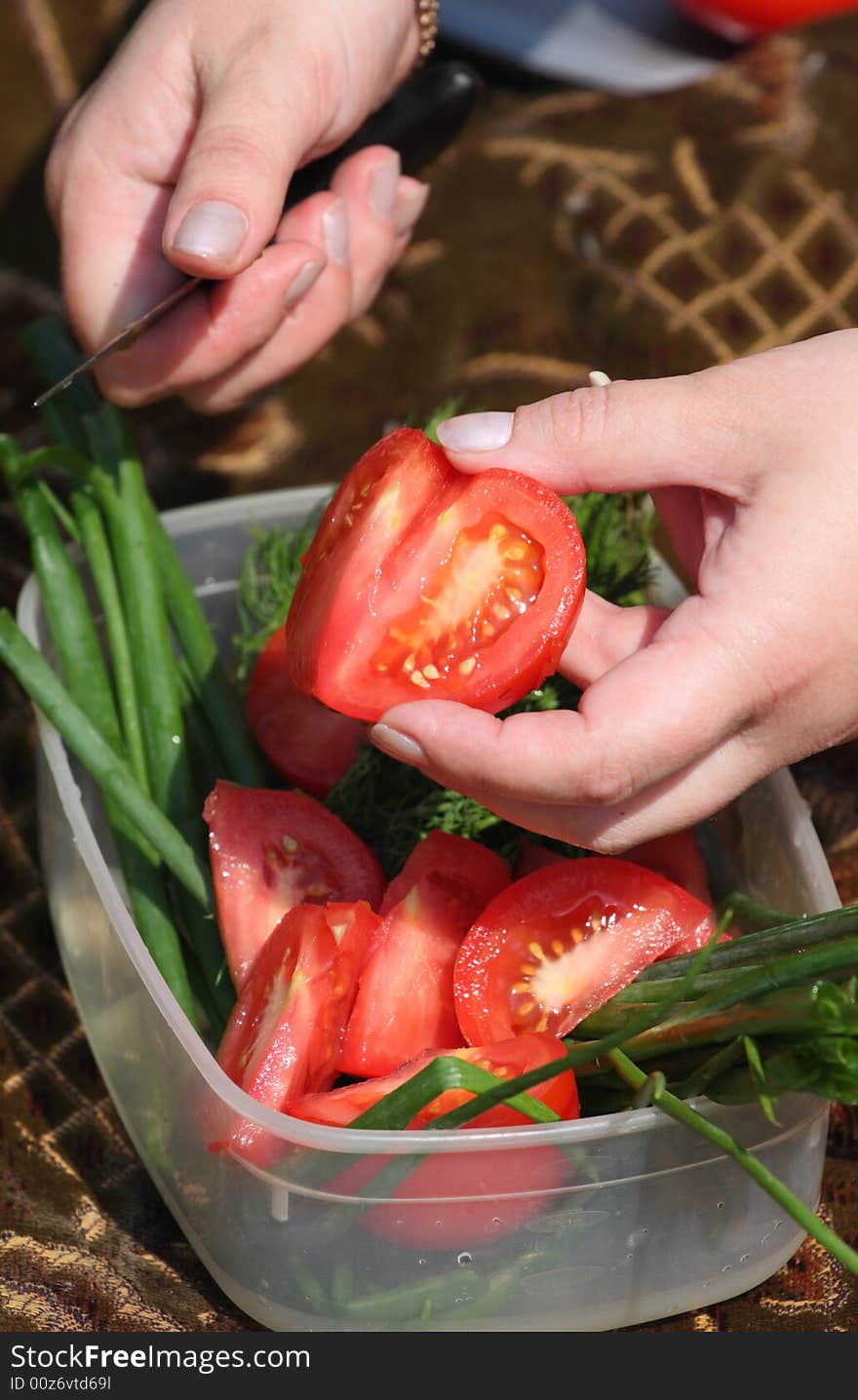 Hands Of The Girl Cut A Tomato