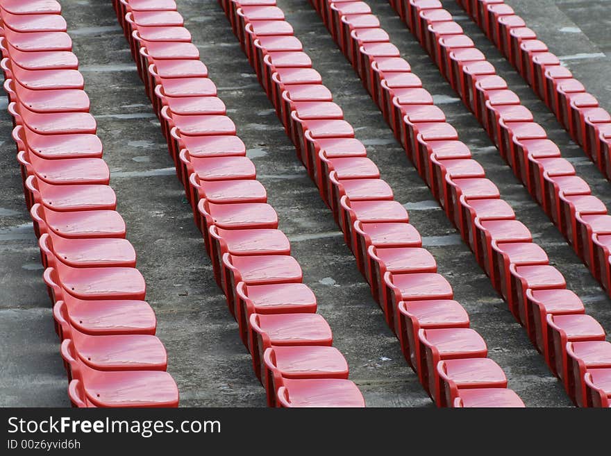 Empty red chairs in open-air arena