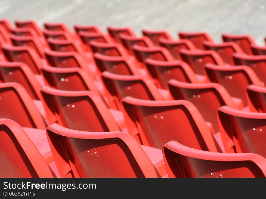 Empty red chairs in open-air arena