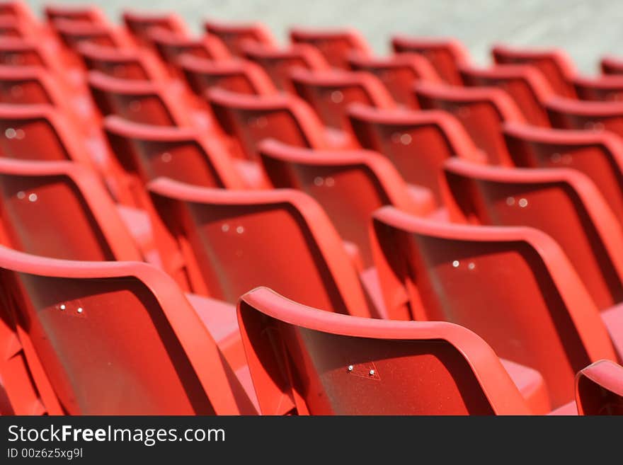 Empty red chairs in open-air arena