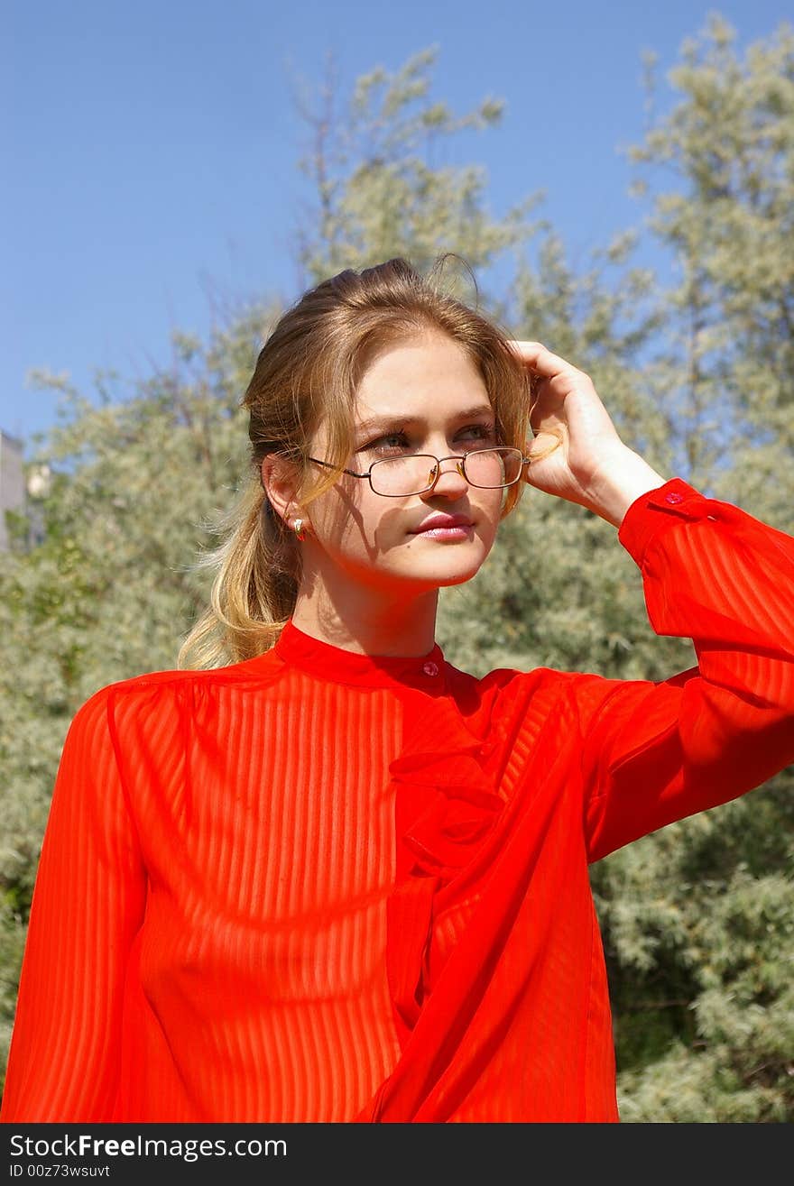 The beautiful young woman in red on the nature