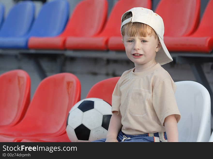 The boy with a toy on empty tribunes of stadium. The boy with a toy on empty tribunes of stadium