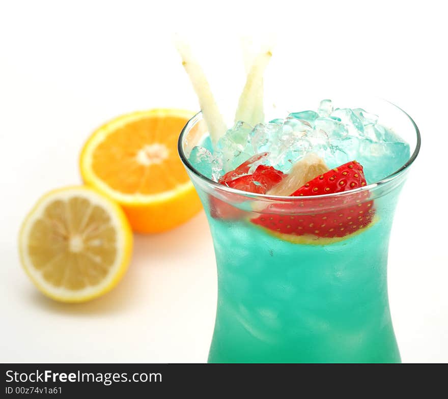 Tropical Acoholic Drink Made of Rum, Pineapple Juice, Blue Curacao, Sweet and Sour Mix. Slice of Apple and Strawberry as a Garnish. Tropical Acoholic Drink Made of Rum, Pineapple Juice, Blue Curacao, Sweet and Sour Mix. Slice of Apple and Strawberry as a Garnish.