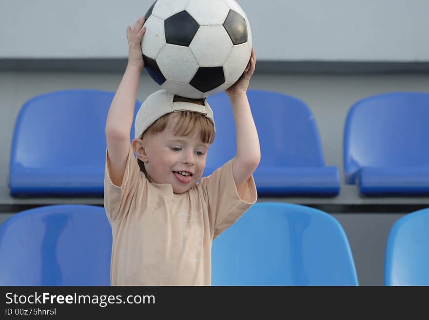 The boy with a ball on tribunes of stadium