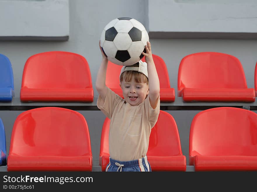 The boy with a ball on tribunes of stadium