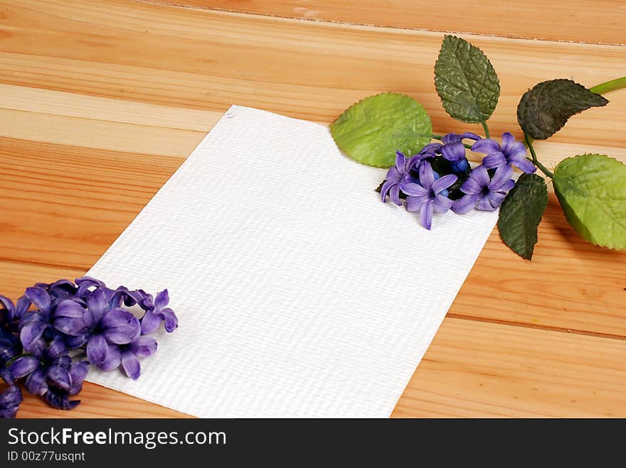 Love letter background with flowers - blank piece of paper laying on the table, place for additional text or logo. Love letter background with flowers - blank piece of paper laying on the table, place for additional text or logo