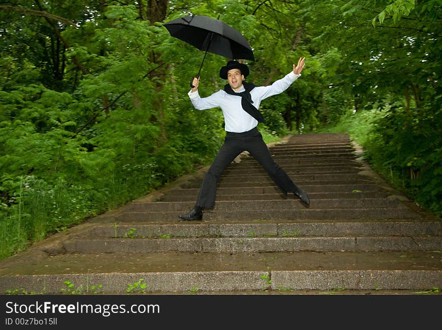 The man with umbrella jumping on a stair. The man with umbrella jumping on a stair.