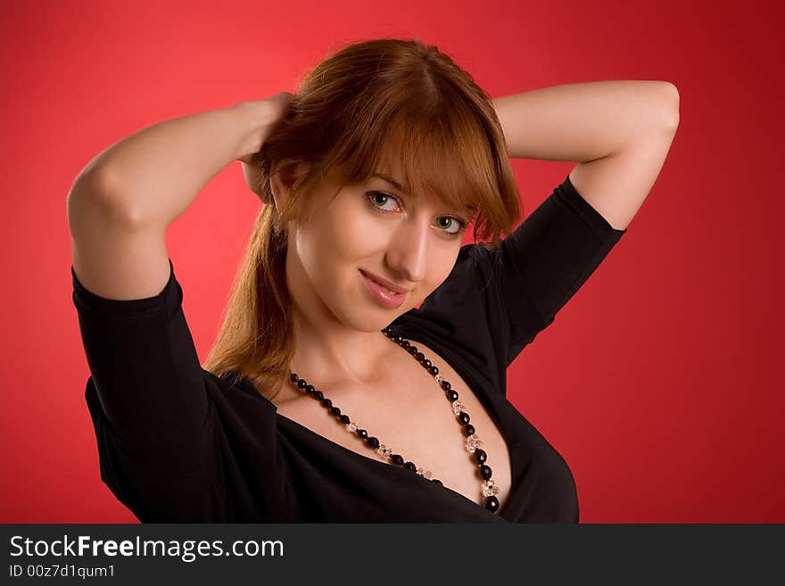 Attractive girl in evening dress isolated on red background