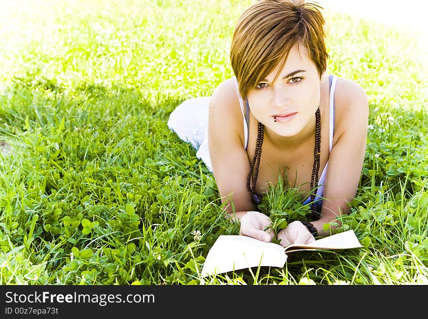 Beautiful blond woman reading over the grass. Beautiful blond woman reading over the grass.