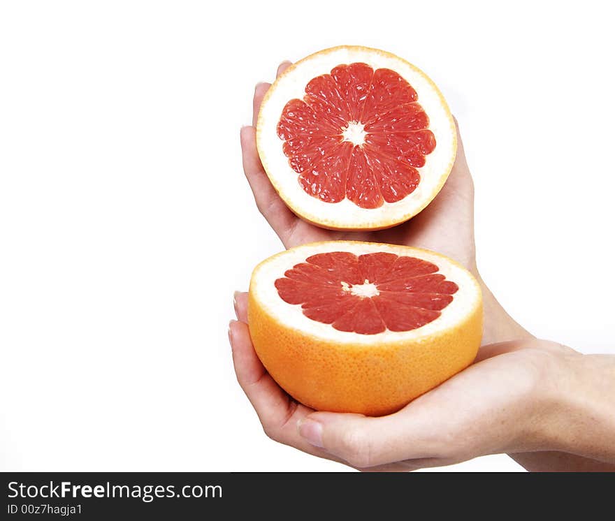 Closeup of hand holding a cut, bright red grapefruit on white. Closeup of hand holding a cut, bright red grapefruit on white