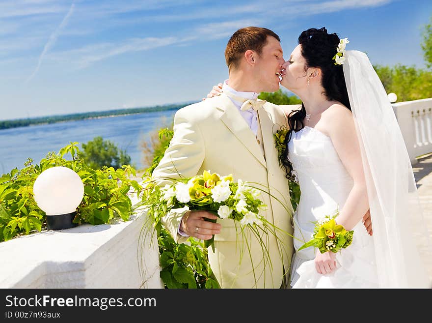 Bride and groom kissing near the street lamp. Bride and groom kissing near the street lamp