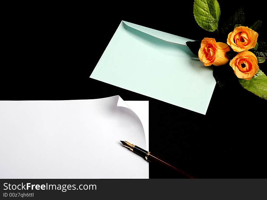 Envelope with blue flowers on black background with pen and piece of paper - place for additional text or logo. Envelope with blue flowers on black background with pen and piece of paper - place for additional text or logo