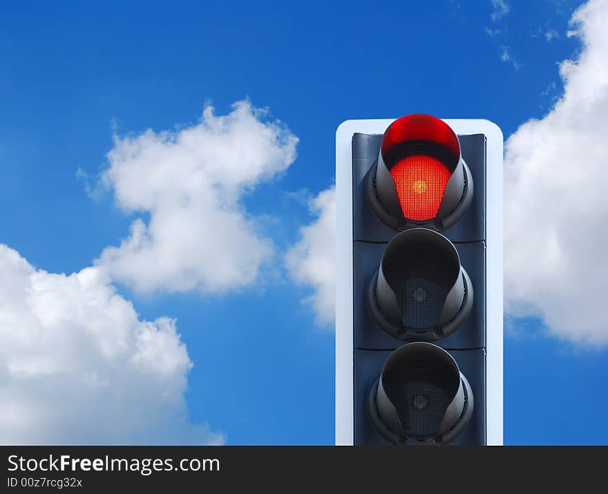 Red traffic light against cloudy blue sky. Red traffic light against cloudy blue sky